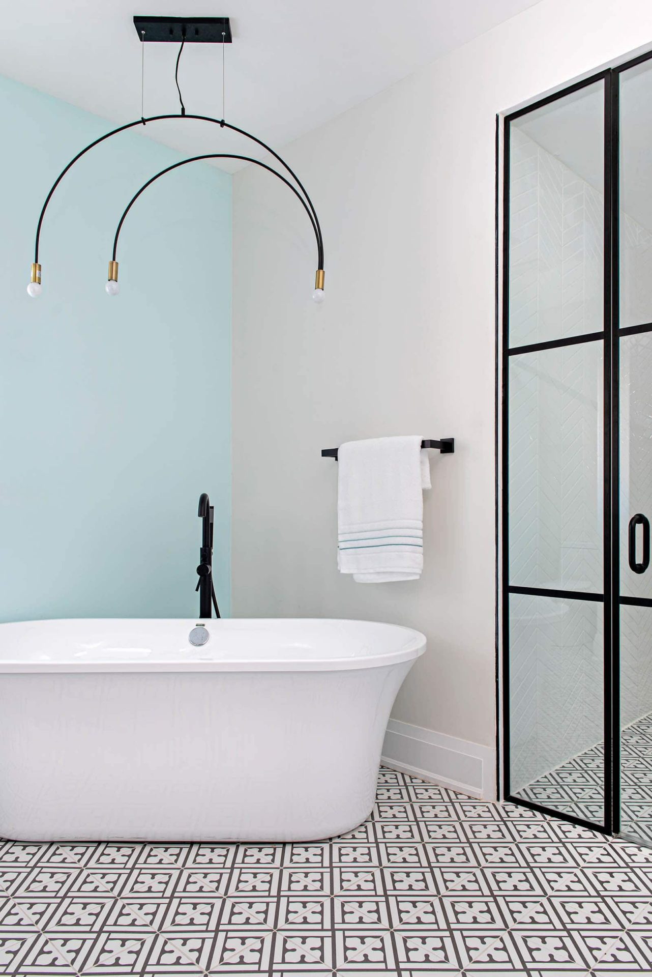 Master ensuite freestanding tub design. Black shower doors and pattern tile