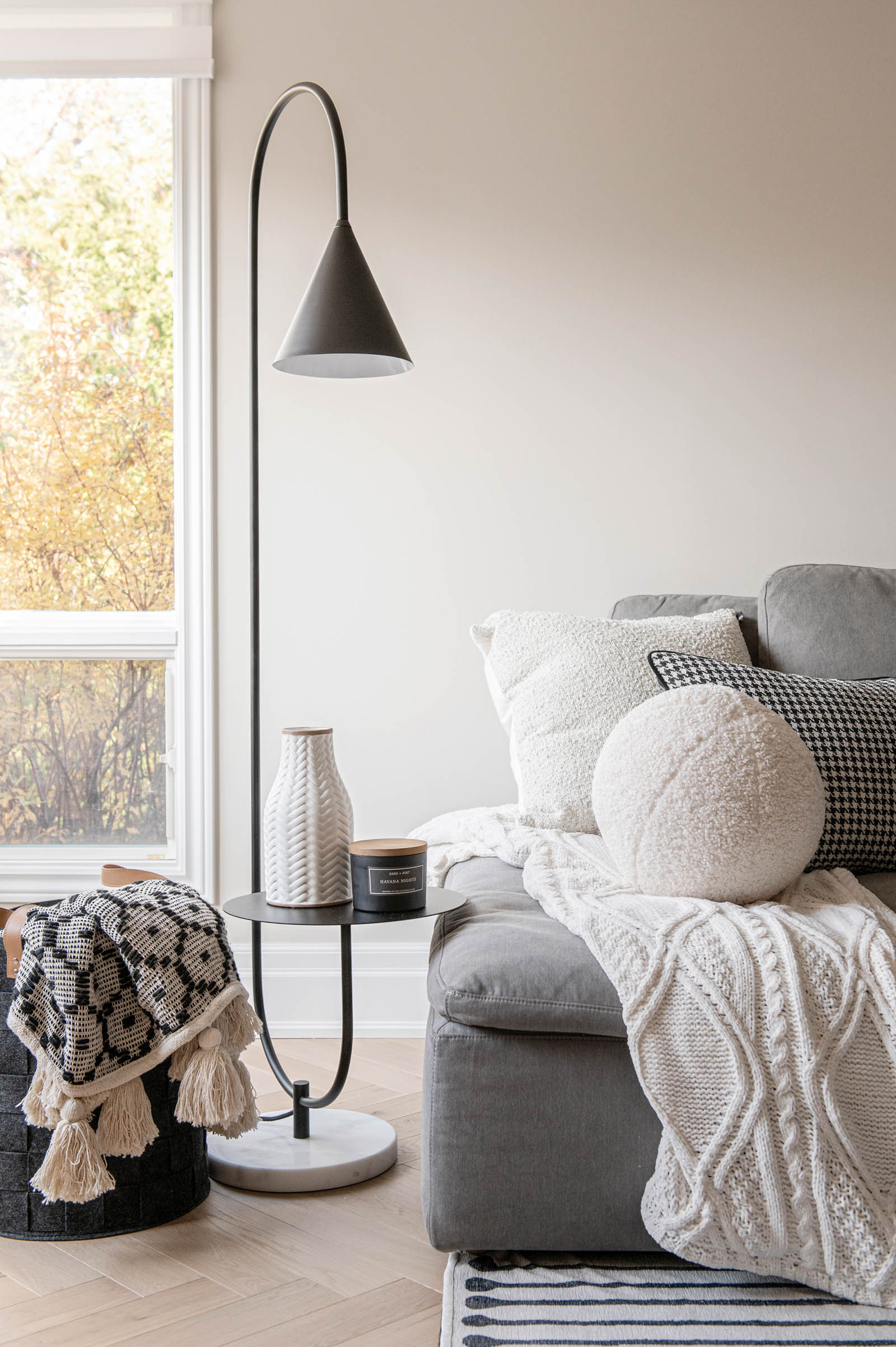 Image of Family Room grey sectional with knitted blanket, houndstooth throw pillow.