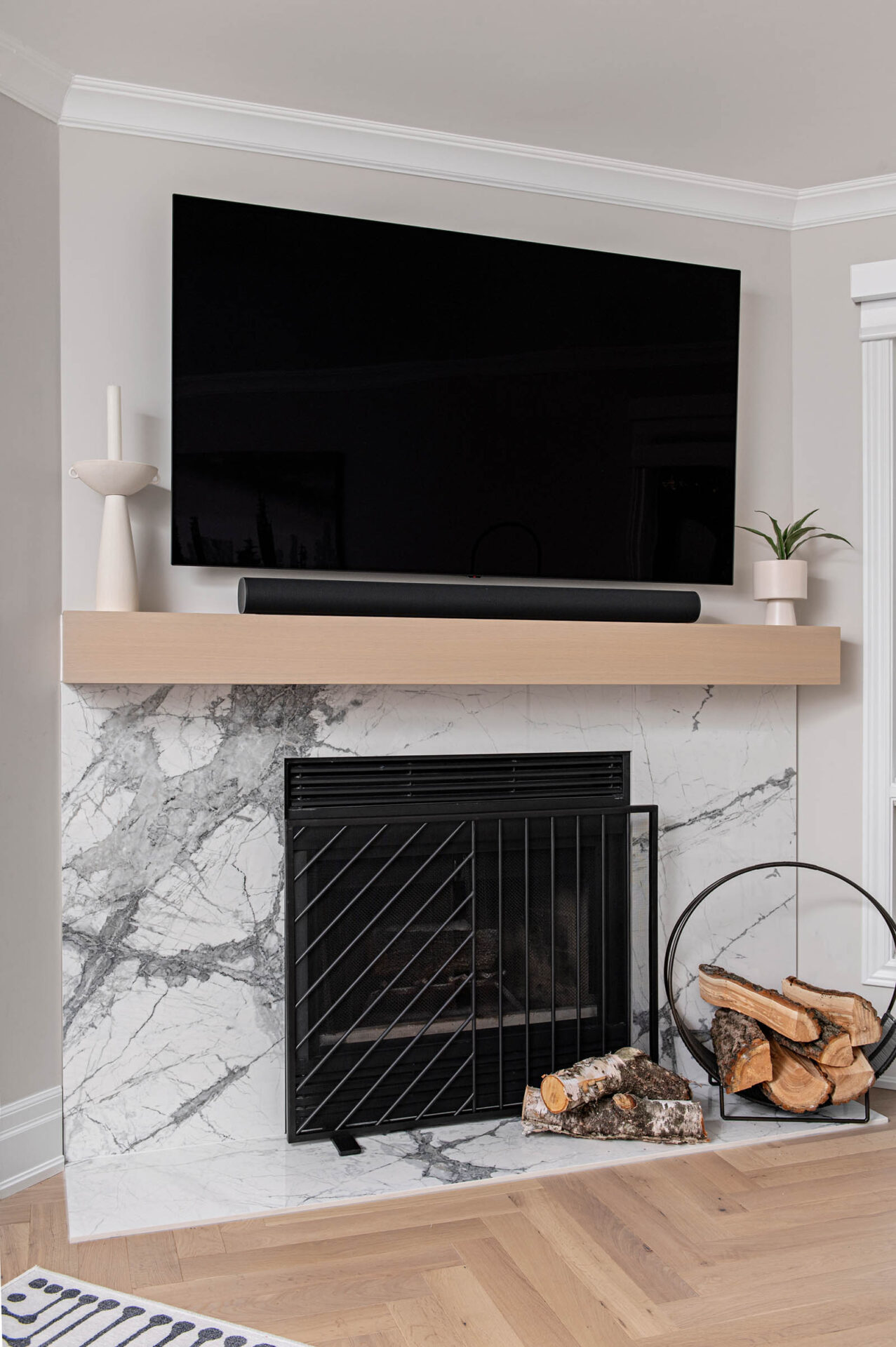 Image of wood burning fireplace with porcelain slab and natural oak mantel.