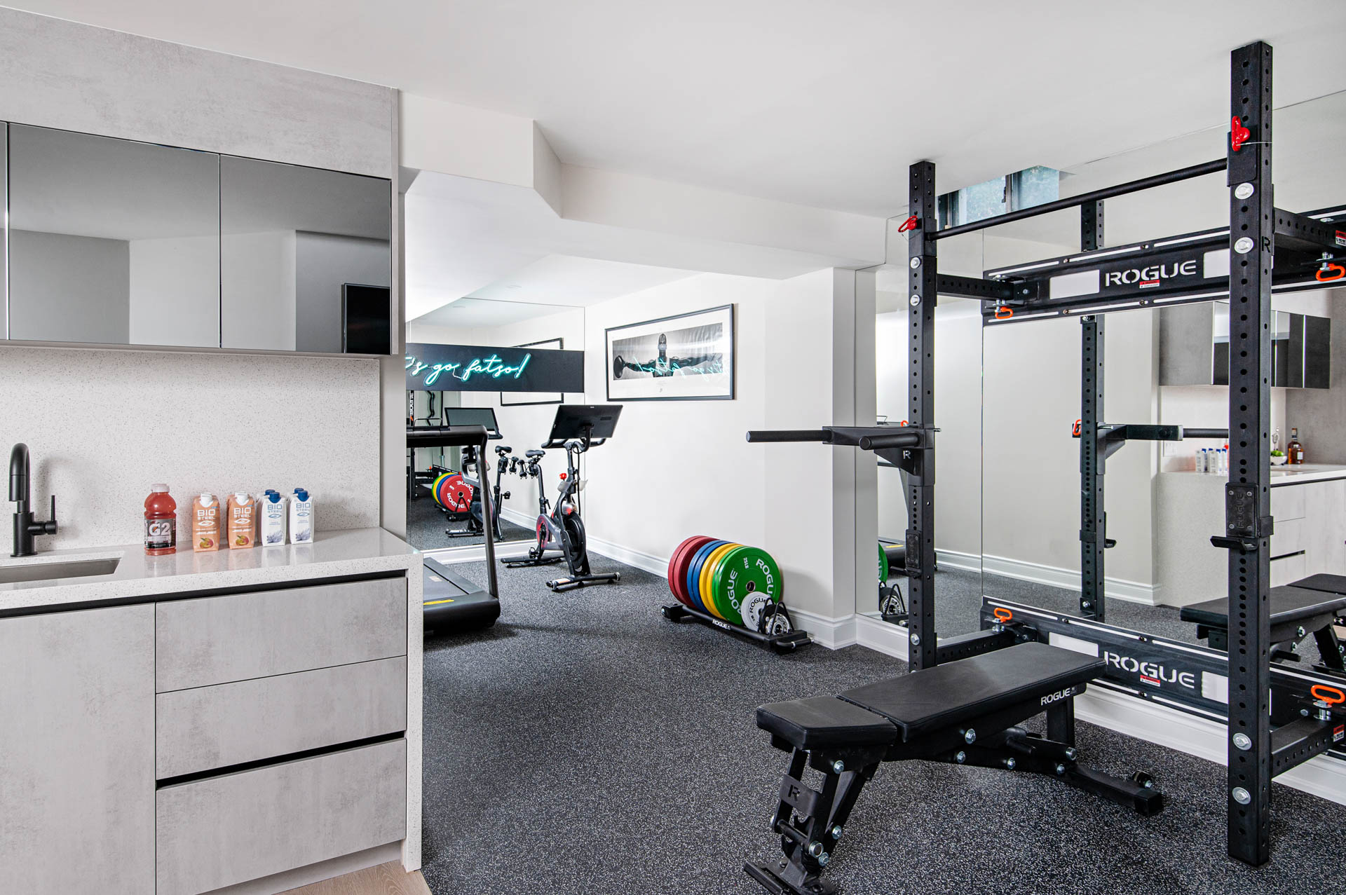 Image of a home gym located in the basement with a glimpse of the bar.