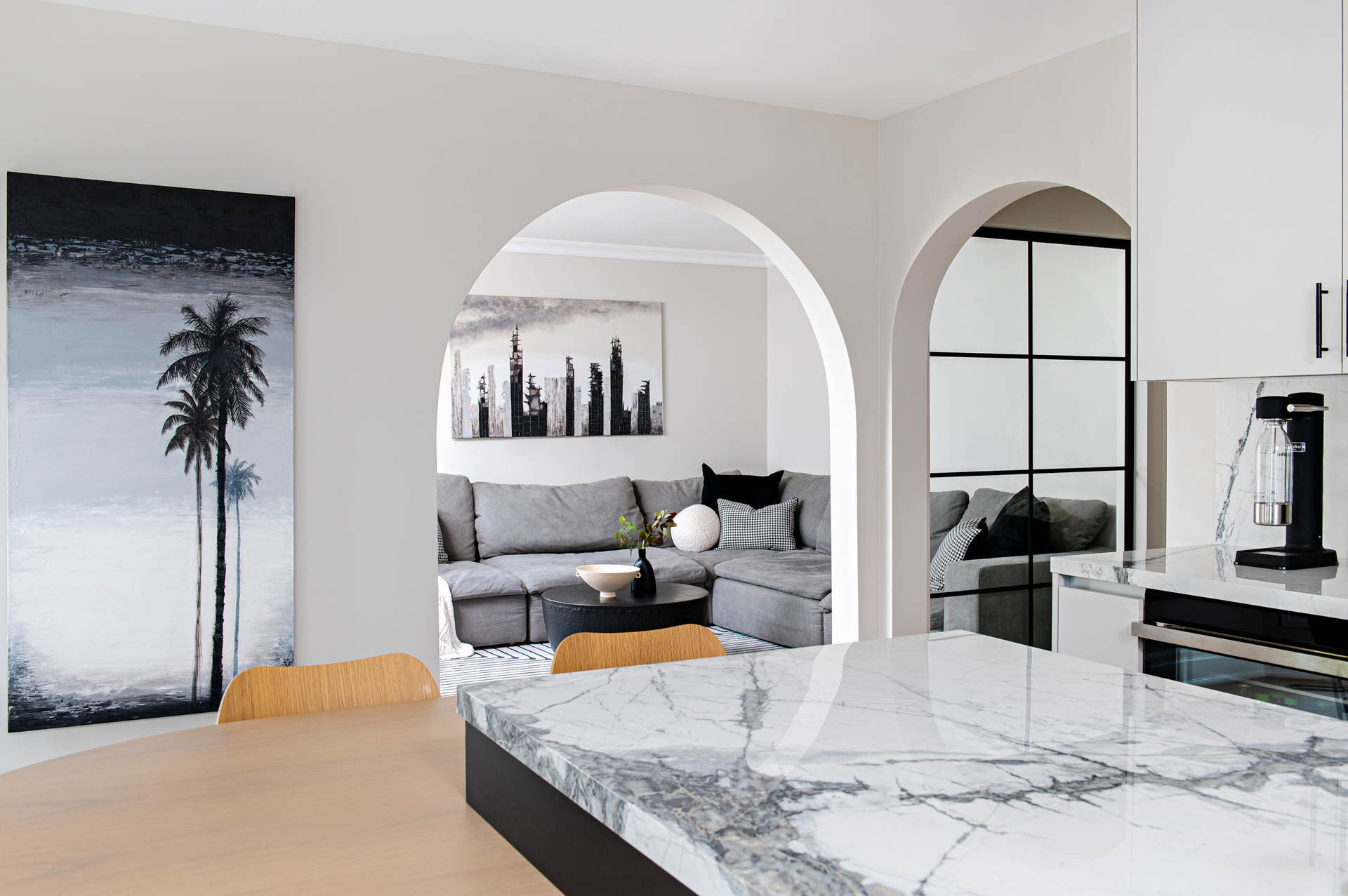 Image of Contemporary kitchen view through the arched opening into the family room.