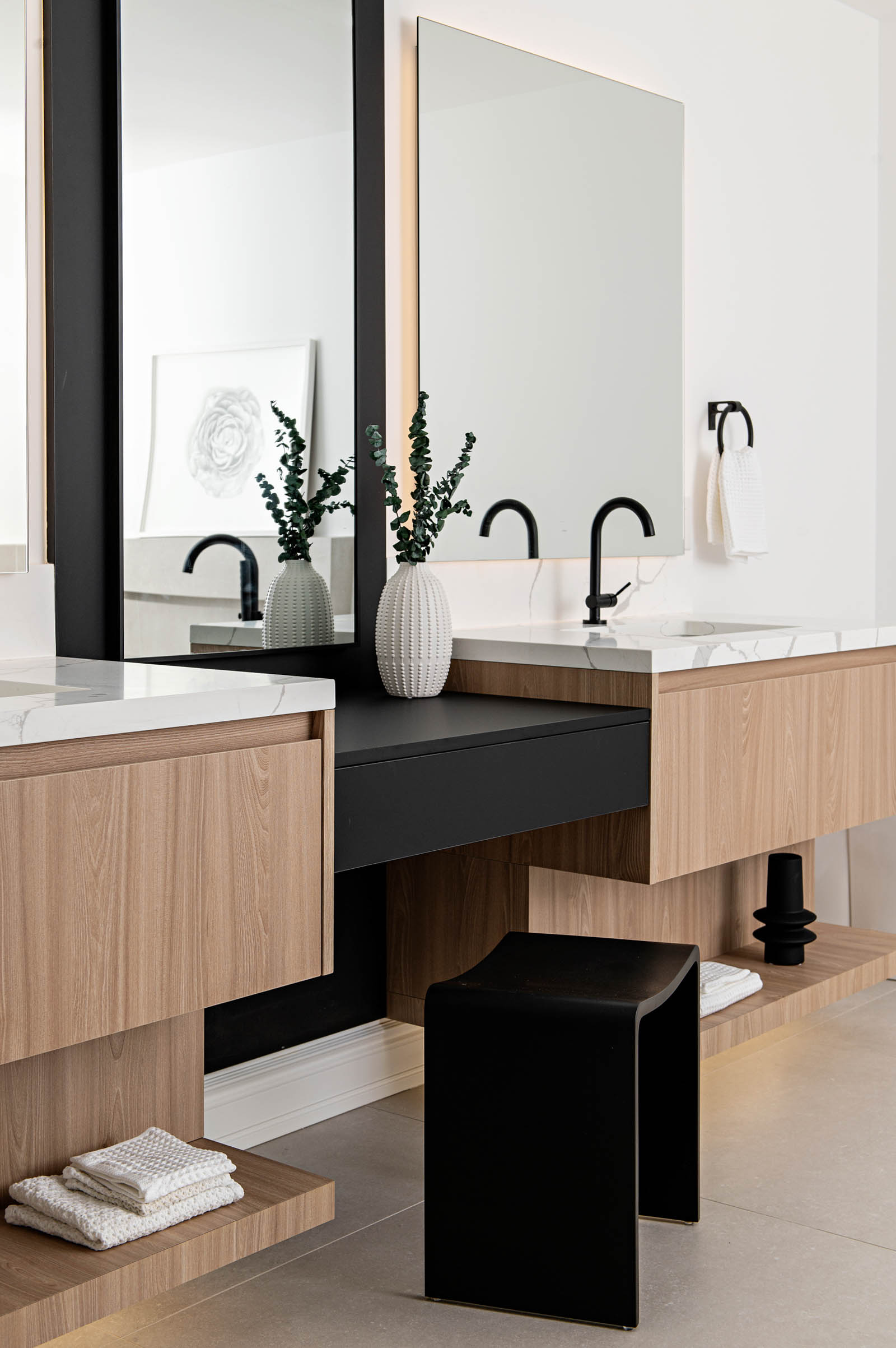 Image of a Contemporary primary ensuite bathroom, showcasing a double wood floating vanity with shelf and white quartz countertop, backlit mirror, black makeup vanity.