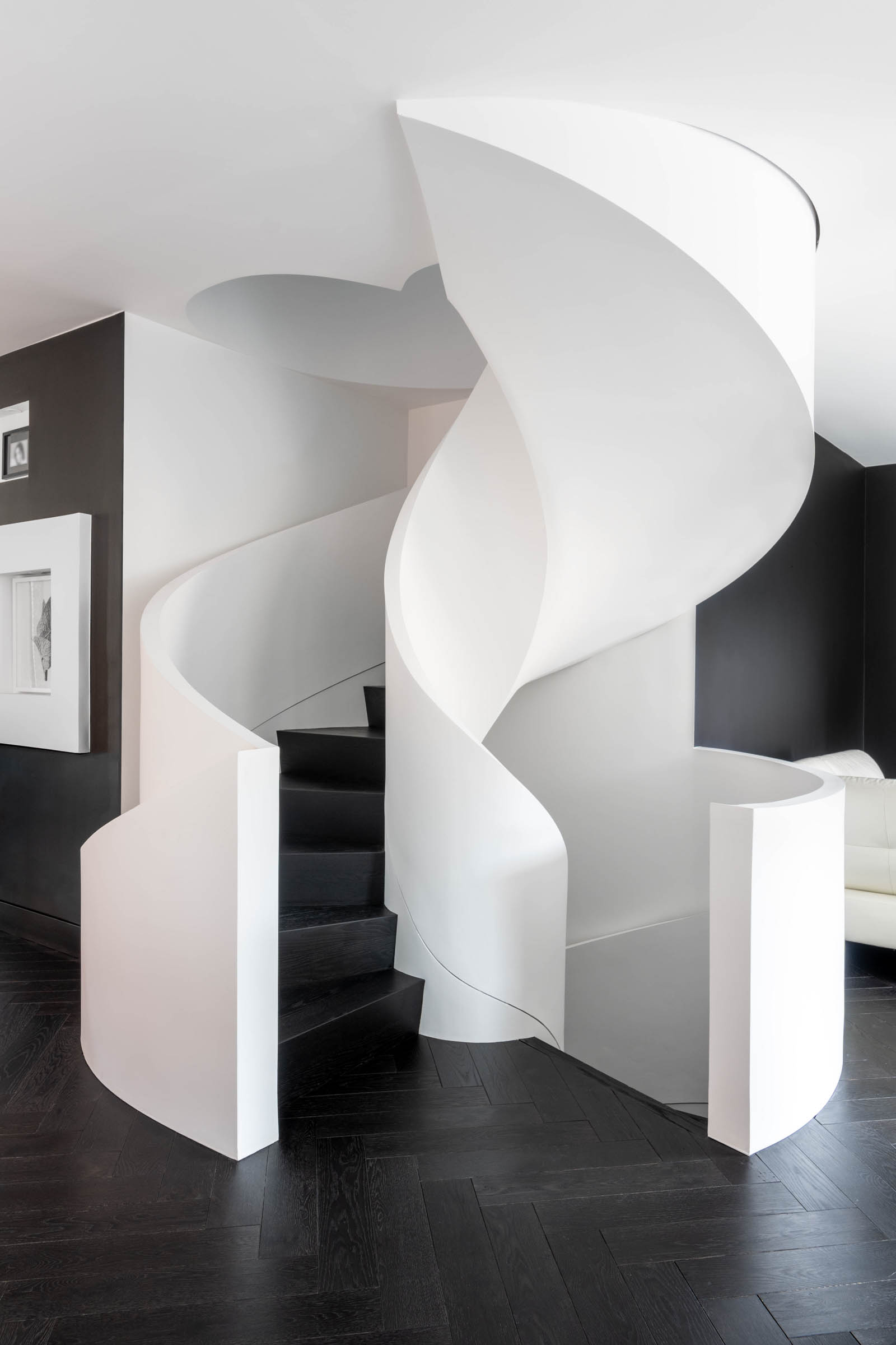 Image of Contemporary curved staircase, black engineered hardwood and white drywall railing.