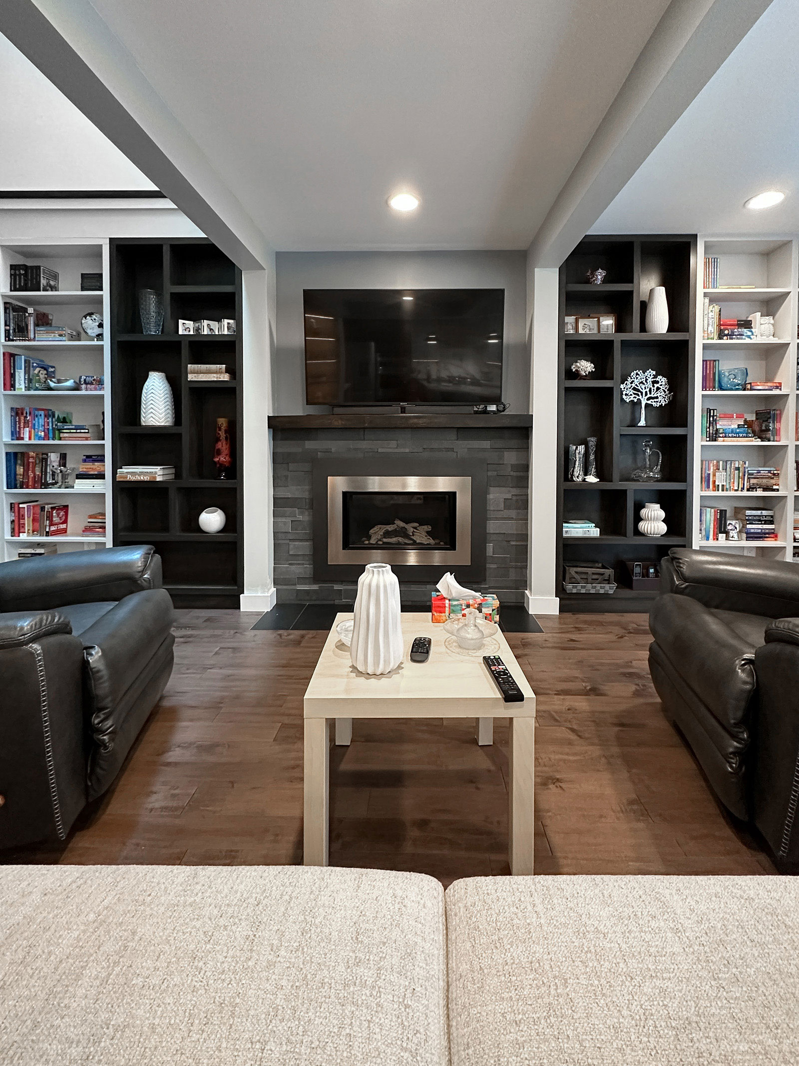 Family room with custom bookshelves and existing fireplace at Bayview Residence