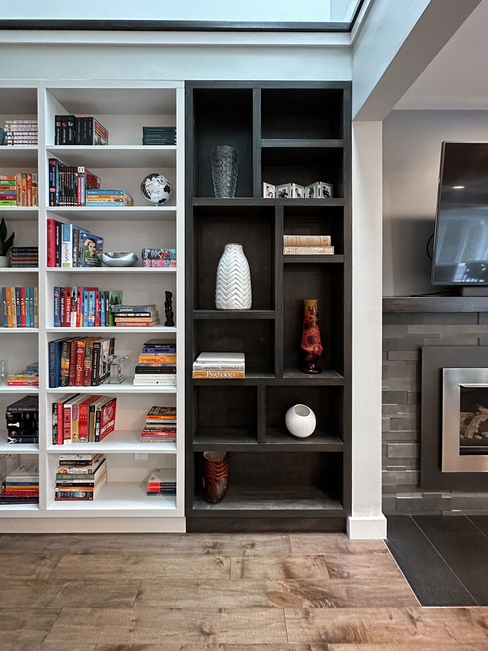 Custom-built bookshelves next to existing fireplace at Bayview Residence