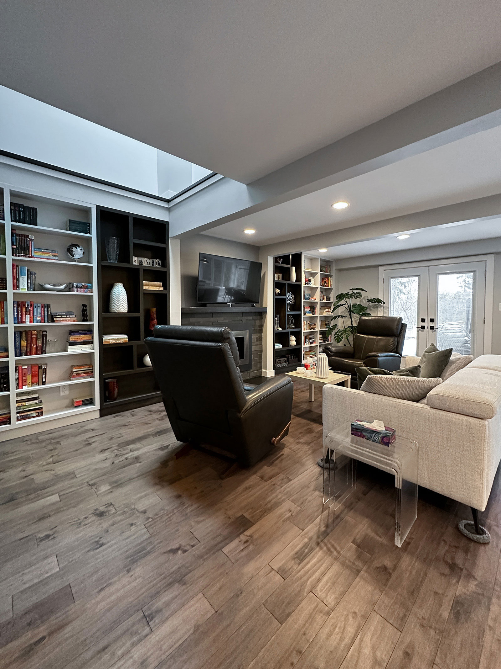 Family room with custom-built bookshelves and existing fireplace at Bayview Residence